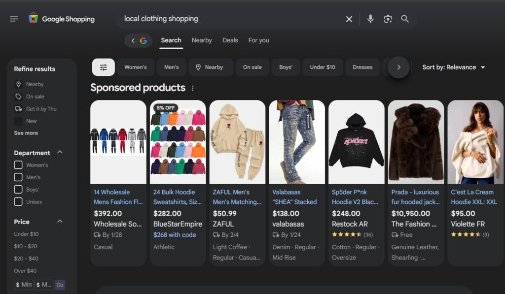 An Example of a Shopping Campaign Ad A screenshot of a Google shopping search for "local clothes shopping". displaying sponsored products for various hoodies and pants.